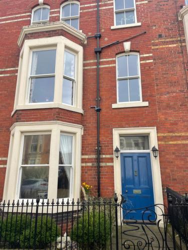 a red brick building with a blue door at Bleak House in Whitby