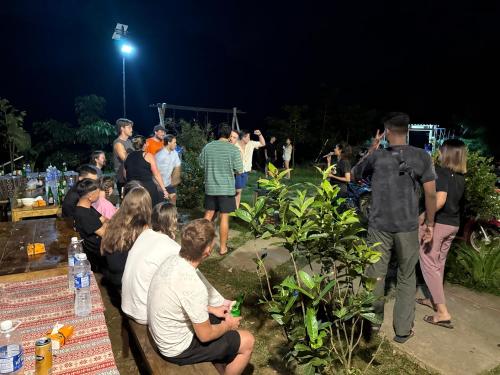 a crowd of people standing in a garden at night at Du peak home in Làng Cac