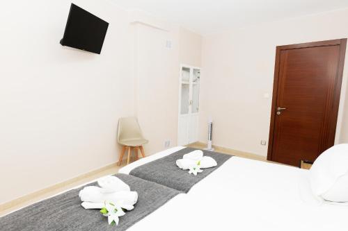 a bedroom with a bed with white towels on it at Apartamento Uso Turistico Ancora de Oro in Fisterra