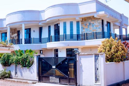 a large white house with a black gate at The Moon Apartments in Rubavu
