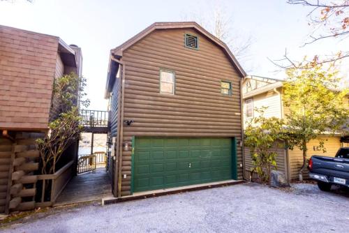 a wooden house with a green garage door at Enchanting Cabin with Breathtaking Sunset and Lake Views in North Carolina in Glenville