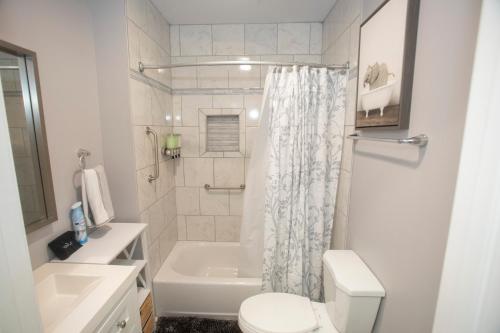 Un baño blanco con inodoro y lavabo. en Comfy 3BD-2BA Near Colleges,Tanger, Coliseum, en Fisher Park