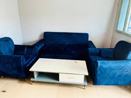a living room with two blue couches and a coffee table at STUDIO BENEGo in Ouagadougou