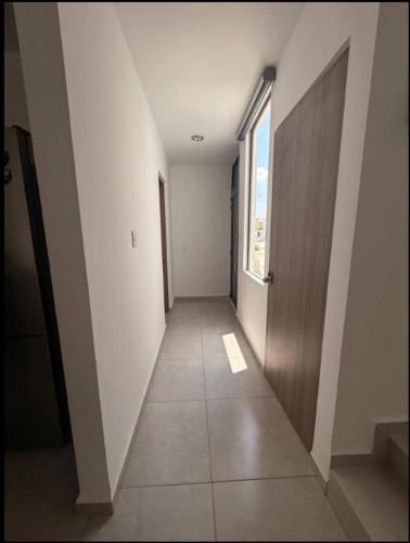 an empty hallway with a door and a window at Acogedora casa en Capittala Leon-Facturamos in Santa Gertrudis