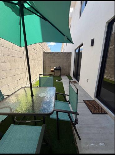 a table and chairs with an umbrella on a patio at Acogedora casa en Capittala Leon-Facturamos in Santa Gertrudis