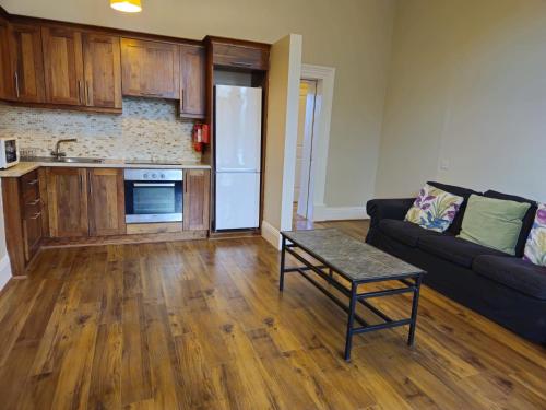 a living room with a couch and a kitchen at Victoria on the Park in Dublin