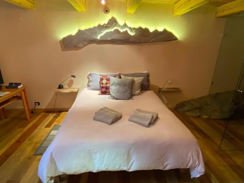 a bedroom with a large white bed with two pillows at L'Albero parlante- affittacamere del Bosco Incantato di Ostana con colazione inclusa in Ostana