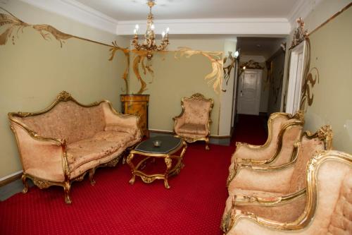 a living room with chairs and a table and a chandelier at Pensiunea Paradis in Râmnicu Vâlcea