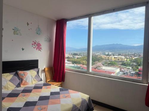 a bedroom with a bed and a large window at La Fortuna Roja in San José