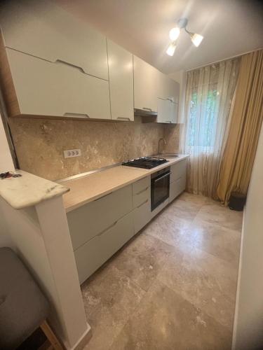 a kitchen with white cabinets and a stove top oven at Ywa in Râmnicu Vâlcea