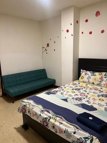 a bedroom with a bed and a green couch at La Fortuna Roja in San José