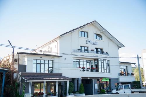 a white building with a sign on it at Pensiunea Paradis in Râmnicu Vâlcea
