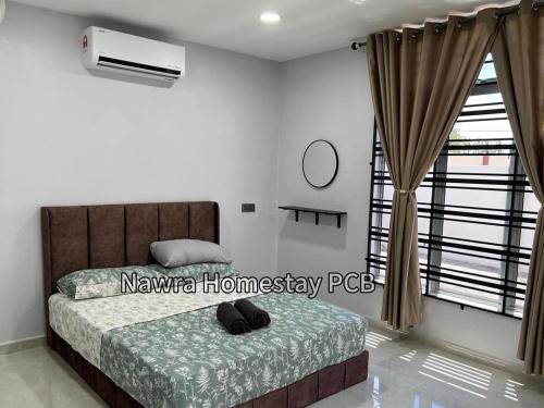 a bedroom with a bed and a window at Nawra Homestay PCB in Kota Bharu