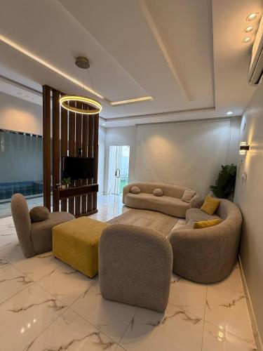 a living room with a couch and two chairs and a television at شاليهات لاتيرا السكنيه Latera Residential Chalets in Taif