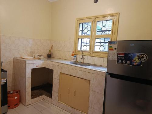a kitchen with a sink and a refrigerator at Blissful abode in Kisumu