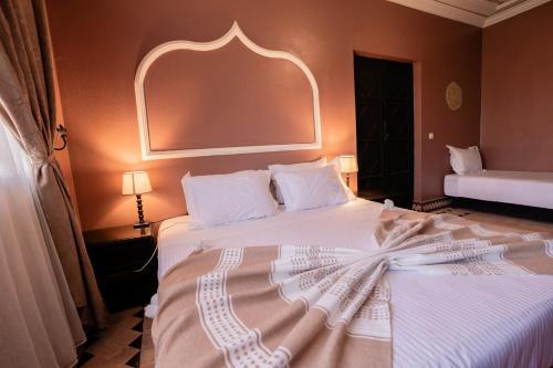 a bedroom with a large white bed with an arch above it at Villa Marrakchia - Palais d'hôtes & spa in Marrakech