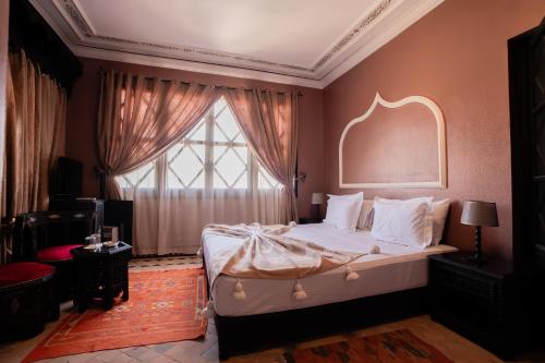 a bedroom with a bed with a large window at Villa Marrakchia - Palais d'hôtes & spa in Marrakech