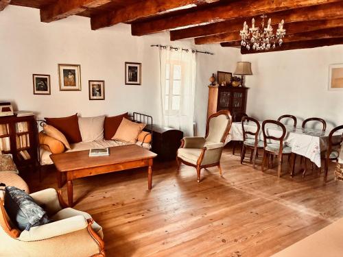 un salon avec un canapé, une table et des chaises dans l'établissement La Maison près de la Fontaine, à Salles-sous-Bois