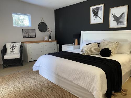 a bedroom with a large white bed and a chair at Namaste Cottage - Garden Facing 2-sleeper Hideaway in Paternoster