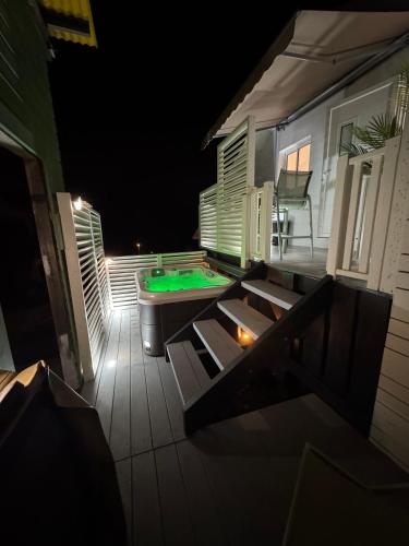 an outdoor deck with a pool table and a pool table at Le Cocoon SPA du MAIDO in Le Guillaume