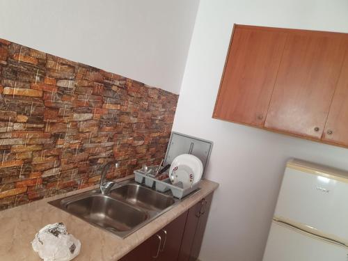 a kitchen with a sink and a brick wall at Room zero of Sea in Borsh