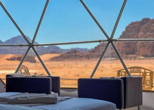 a tent with two beds and a view of the desert at WADI RUM TARA lUXURY CAMP in Wadi Rum