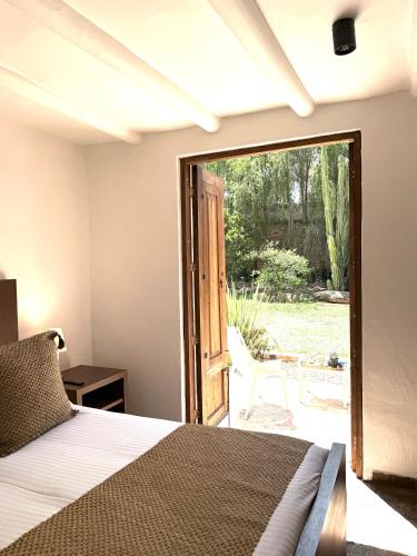 a bedroom with a bed and a sliding glass door at Hotel Casa Terra in Villa de Leyva