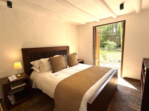 a bedroom with a large bed and a large window at Hotel Casa Terra in Villa de Leyva