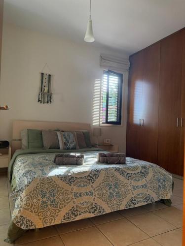 a bedroom with a large bed and a window at Tranquil Poolside apartment with stunning views in Mazotos