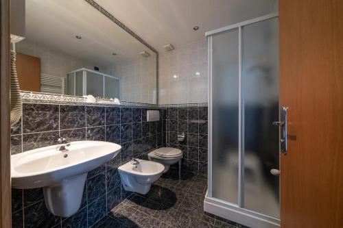 a bathroom with a sink and a toilet at HOTEL CAVALIERI in Pinerolo