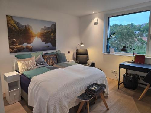 a bedroom with a bed and a desk and a window at Stadtnahes Gästezimmer im Penthouse bei Esi in Tübingen