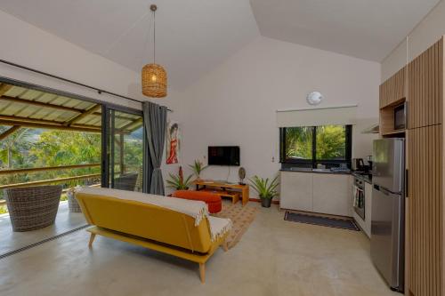 シャマレルにあるTree Top View Lodgeのリビングルーム(黄色のソファ付)、キッチンが備わります。