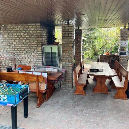 a patio with benches and a table and a table and benches at Rózsás Vendégház in Szólád