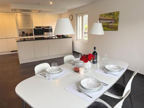 a white dining room table with white chairs and a white at Ferienhaus Birds No 11 Lauchringen in Lauchringen