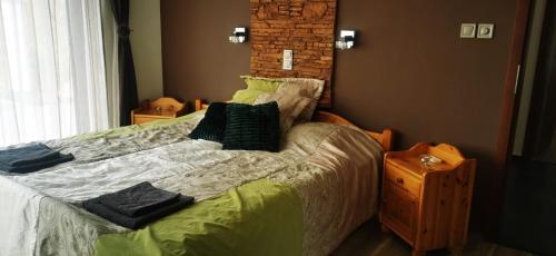 a bedroom with a bed with pillows on it at Rózsás Vendégház in Szólád