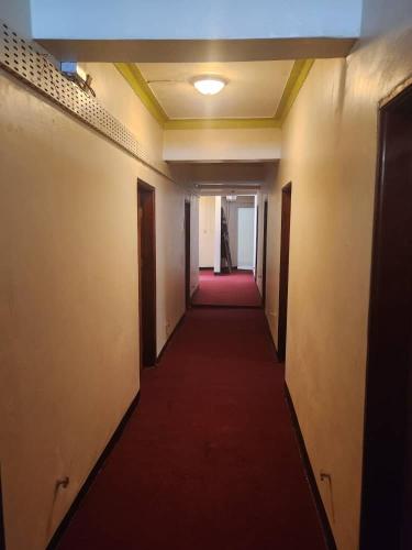 a long hallway with a red carpet in an office building at Kaa Highway Hotel in Mukono