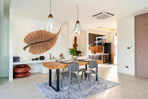 a kitchen and dining room with a wooden table and chairs at Sunny Day Dream Villa - Nai Yang Beach in Thalang