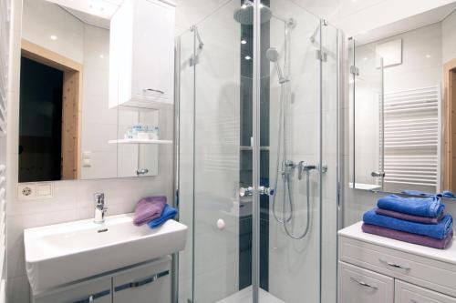 ein Bad mit einem Waschbecken und einer Dusche in der Unterkunft Appartementhaus Marina in Matrei in Osttirol