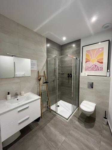 a bathroom with a shower and a toilet and a sink at Ô Happy Daix in Daix