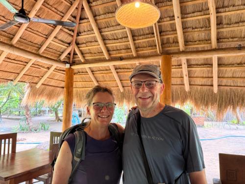 a man and a woman standing under a wooden roof at Agro Village Resort , Kalpitiya in Kalpitiya