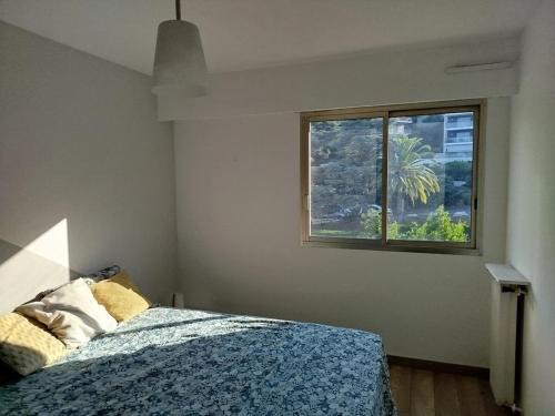 ein Schlafzimmer mit einem Bett und einem Fenster in der Unterkunft Wonderful sea view apartment in Nizza