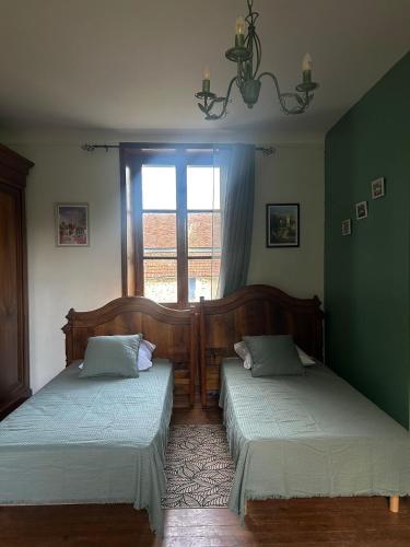 due letti in una stanza con finestra di la DROMOISE DU LOT a Saint-Sozy