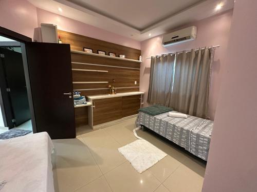 a bedroom with a bed and a desk and a window at Pleasant place near Manaus airport in Manaus