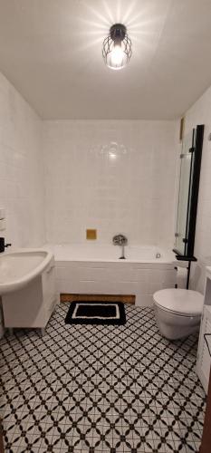 a bathroom with a tub and a sink and a toilet at FeWo Prinzregent - große Zentrale Wohnung, ideal für Gruppen & Familien in Bad Kissingen