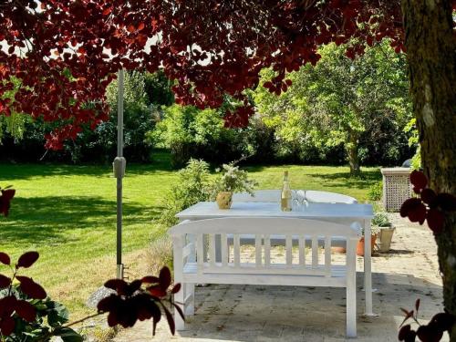a white table in a garden under a tree at 8015-Kalvehave-Hasselvej-3 in Kalvehave