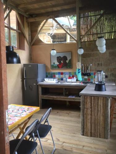 a kitchen with a table and chairs and a refrigerator at Chalets HUITACA in Choachí