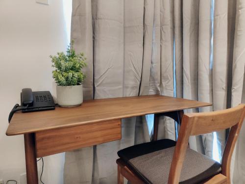 a desk with a phone and a potted plant on it at Tiny Oasis at Tambuli Seaside Living in Maribago