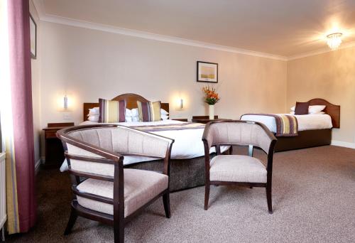 a hotel room with two beds and two chairs at The Old Golf House Sure Hotel Collection by Best Western in Huddersfield