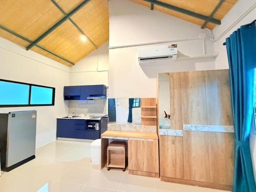 Una cocina con electrodomésticos azules y blancos y una cortina azul. en The House Pai 1-3, en Pai