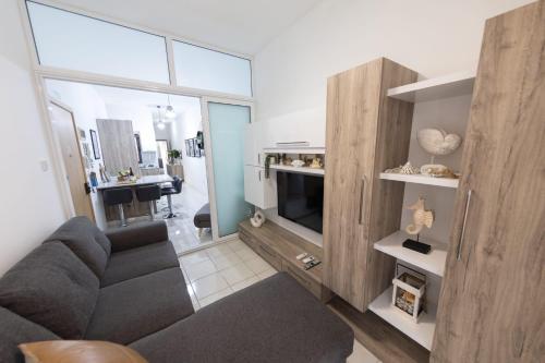 a living room with a couch and a television at Seaside Escape Birzebbuga in Birżebbuġa